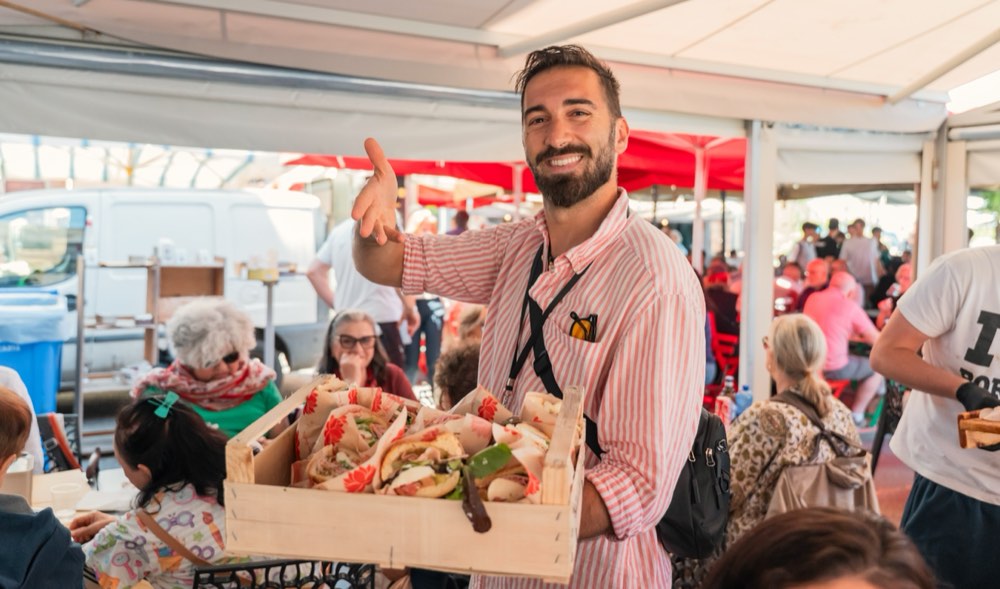 Dario holding a crate of freshly made Sicilian panini at the Ortigia street market in Syracuse